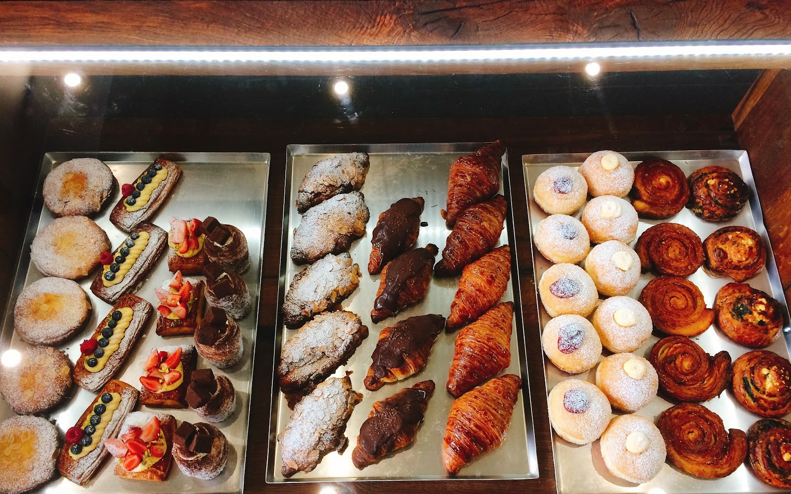Trays of danishes, cruffins, croissants and doughnuts seen from above